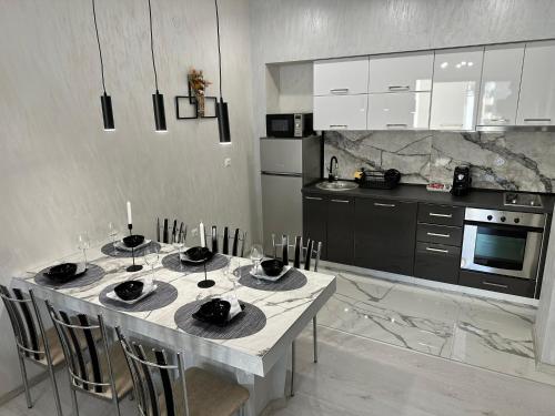 a kitchen with a table with four chairs and a kitchen with at LT Apartment in Vratsa