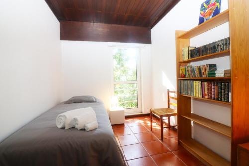 een slaapkamer met een bed en een boekenplank bij Casa dos Filhos - Casas do Rio by Gerês Casas in Vieira do Minho