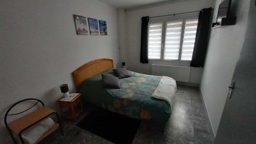 um pequeno quarto com uma cama e uma janela em Le Bellevue em Givet