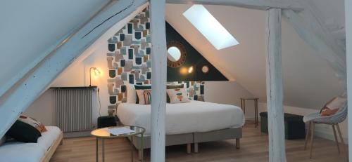 une chambre avec un lit blanc dans un grenier dans l'établissement Au Lampadaire Briarois, à Briare