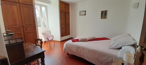 une chambre avec un lit, un bureau et une fenêtre dans l'établissement Chambres d'Hôtes, Domaine Les Peupliers, Lagnes, à Lagnes