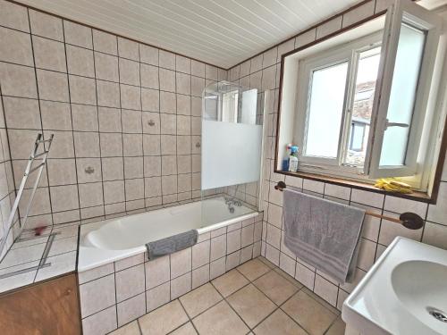 ein Badezimmer mit einer Badewanne und einem Waschbecken in der Unterkunft Triplex Sisley - Maison Atypique avec Cour Extérieure in Moret-sur-Loing