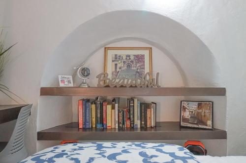 a book shelf with books on it next to a bed at Old San Juan Historic Loft 4 The Adventurous in San Juan