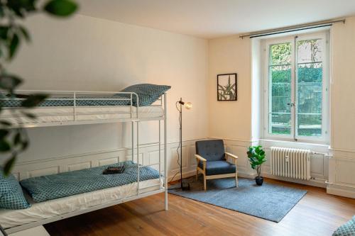 a bedroom with two bunk beds and a chair at Jewel in the center of Thun's old Town in Thun