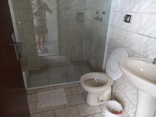 y baño con ducha, aseo y lavamanos. en Espaço Verona-Apartamento econômico duplo c/banheiro e sem café en Fazenda Rio Grande