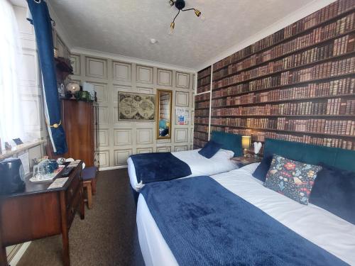 マーゲイトにあるWestbrook Lodge Guest Houseのベッド2台とデスクが備わるホテルルームです。