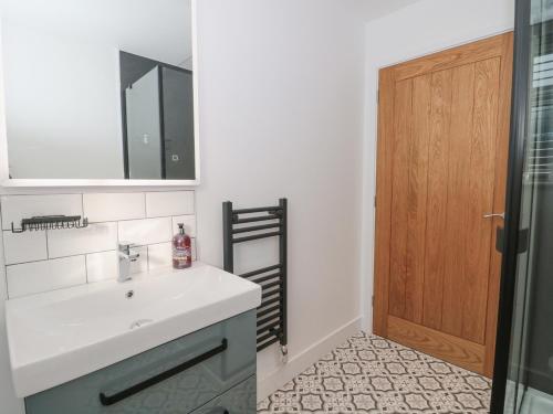 a bathroom with a sink and a wooden door at Little Haven in Blandford Forum