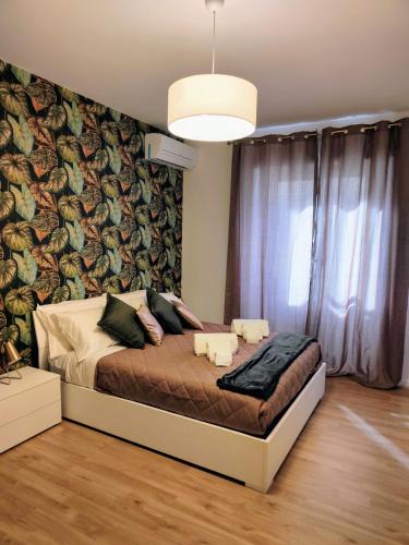a bedroom with a bed and a wall with a mural at Roma Maison Gio' in Rome