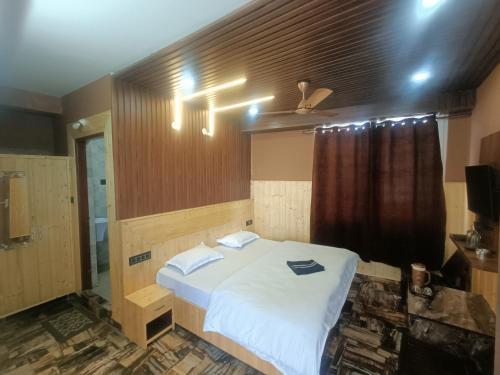- une chambre avec un lit blanc et une fenêtre dans l'établissement Ramandeep Stays, à Dharamshala