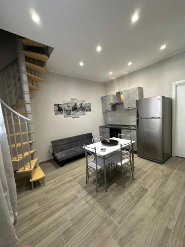 cocina y sala de estar con mesa y nevera en Dimora Gaudiano, en Matera