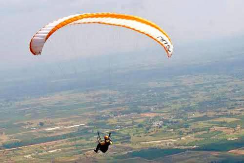 a person flying through the air with a parachute at Nandi Private Residence, Bohemian Hill View Villa in Devanahalli-Bangalore
