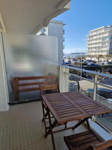 d'une table et d'une chaise sur un balcon offrant une vue sur la ville. dans l'établissement Studio vue mer, à La Baule
