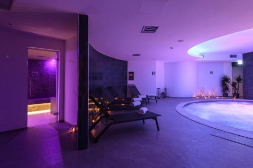 a living room with a pool with purple lighting at Resort La Battigia Beach & Spa in Alcamo Marina
