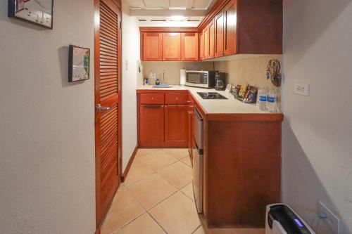 a small kitchen with wooden cabinets and a stove at Old San Juan Historic Loft 4 The Adventurous in San Juan