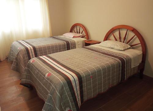 two beds sitting next to each other in a room at Schmidt Hostal in Pozuzo