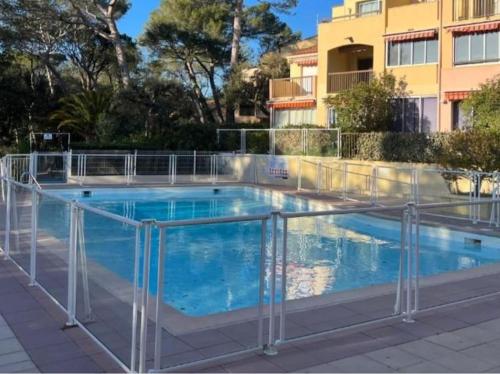 une piscine entourée d'une clôture métallique. dans l'établissement Charmant studio Valescure Saint Raphaël, à Saint-Raphaël