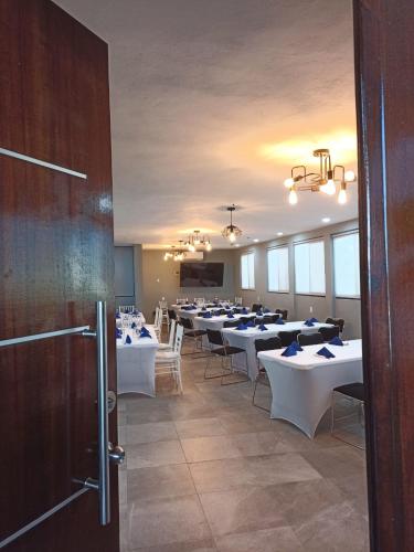 a dining room with tables and chairs in a room at Hotel Villa de Altamira in Altamira