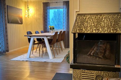 a dining room with a table and a fireplace at Senja, 2 BR apartment, surrounded by the northern lights and the midnight sun in Finnsnes