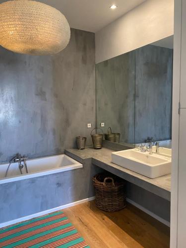 une salle de bain avec deux lavabos, une baignoire et un miroir dans l'établissement Maison de charme à Sète, à Sète