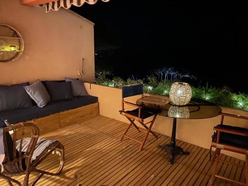 d'une terrasse avec une table et un canapé. dans l'établissement Appartement vue mer, accès privé plage, piscine, à Sainte-Maxime