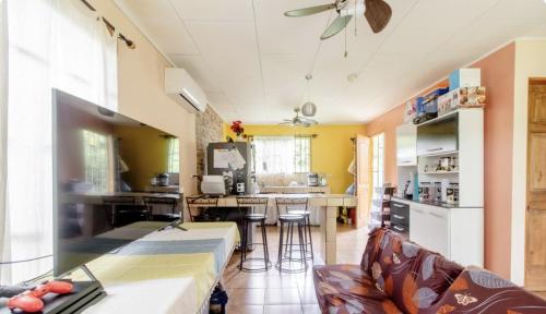 a living room with a couch and a kitchen at Habitación Cerca de las playas y Golfito in Palmar Norte