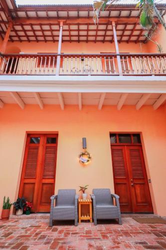 a house with two chairs and a table in front of it at Old San Juan Historic Loft 4 The Adventurous in San Juan