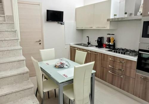 a kitchen with a table and chairs in a room at sciuliddA Casa Vacanze in Avola