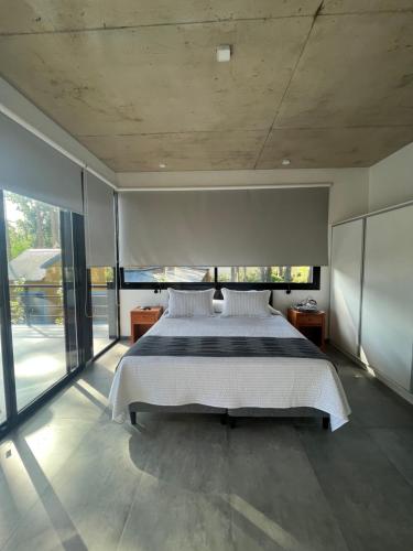 ein Schlafzimmer mit großem Bett und großen Fenstern in der Unterkunft Excepcional Casa en Solanas Resort in Punta del Este