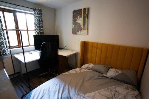1 dormitorio con 1 cama y escritorio con ordenador en Sevenoaks Guest House, en Trimley Heath