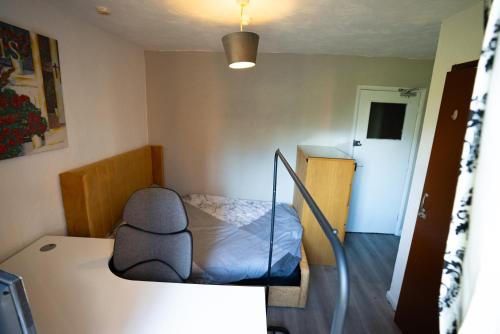 Habitación pequeña con cama y escalera en Sevenoaks Guest House, en Trimley Heath