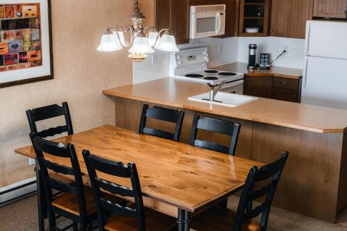 a kitchen with a wooden table with chairs and a sink at Mountain View Resort and Suites at Fairmont Hot Springs in Fairmont Hot Springs