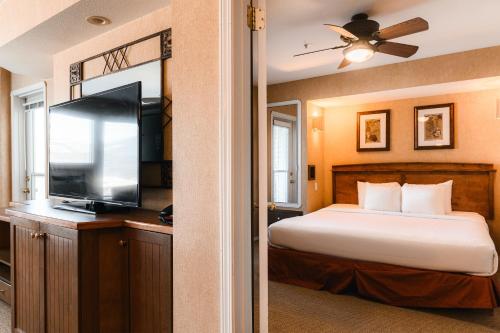 um quarto com uma cama e uma televisão de ecrã plano em Mountain View Resort and Suites at Fairmont Hot Springs em Fairmont Hot Springs