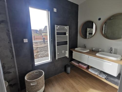 een badkamer met 2 wastafels en een raam bij Carpe Diem in Jullouville-les-Pins