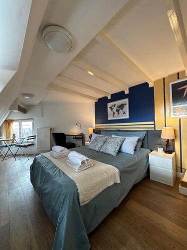 een slaapkamer met een groot bed met blauwe muren bij Dase Maison B&B centrum in Amsterdam