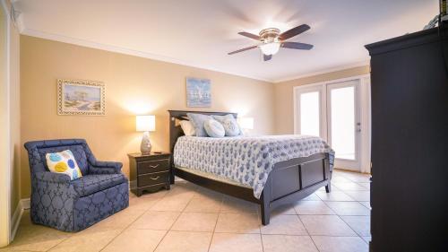 a bedroom with a bed and a chair and a ceiling fan at NEW-The Villas-Pool-BBQ-Casino-Colosseum-Beach-Tennis Courts in Biloxi