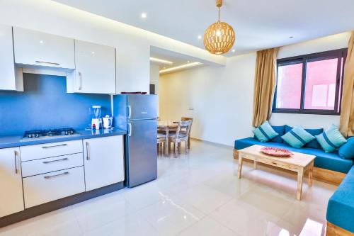 a kitchen and living room with a couch and a table at Hanah Apartments by Living Essaouira in Essaouira