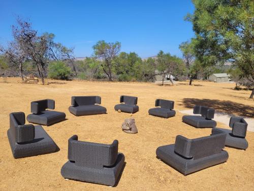 a group of chairs sitting in the middle of a field at Peace Haven @ Windfarm Accommodation in Yzerfontein