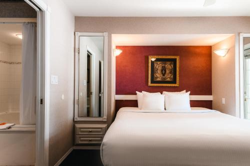 a hotel room with a bed and a mirror at Mountain View Resort and Suites at Fairmont Hot Springs in Fairmont Hot Springs
