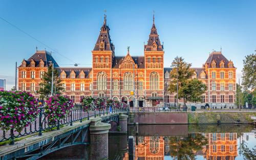 a large building next to a river with a bridge at Luxury House With 2 Private Independent Studios 120 m2 Near LEIDSEPLEIN CITY CENTRE AMSTERDAM - Paid Parking Possibilities Nearby in Amsterdam