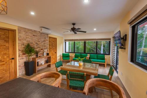 Una sala de estar con una mesa y sillas verdes. en Condominios Brisas del Mar, en Santa Cruz Huatulco