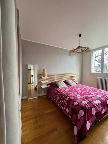 a bedroom with a bed with a purple bedspread at Appartement - Dijon in Dijon