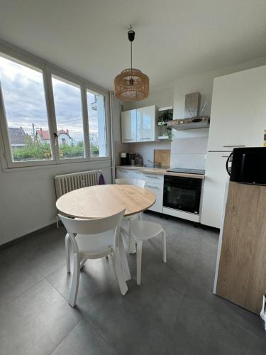 a kitchen with a table and chairs in a kitchen at Appartement - Dijon in Dijon