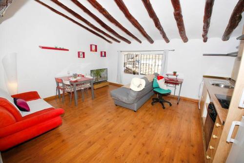 a living room with a red couch and a table at Ático con vistas a la montaña Alcoy in Alcoy