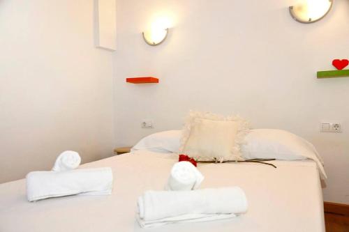 a white bed with a stuffed animal sitting on top of it at Ático con vistas a la montaña Alcoy in Alcoy