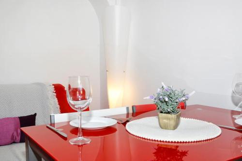 a red table with a glass of wine and a plate at Ático con vistas a la montaña Alcoy in Alcoy