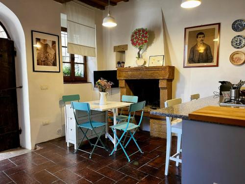 cocina con mesa, sillas y chimenea en Santa Monaca Medieval House, en Sorano