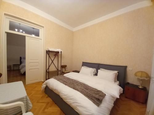a bedroom with a bed with white sheets and a window at Old Gate in Telavi