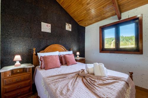 a bedroom with a large bed and a window at Casinha do Quadro in Figueiró dos Vinhos