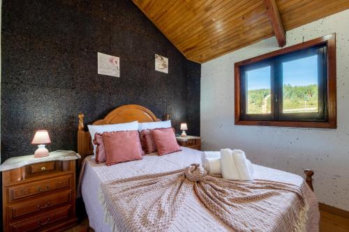 Un dormitorio con una cama grande y una ventana. en Casinha do Quadro, en Figueiró dos Vinhos