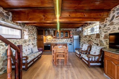 a living room with stone walls and a wooden ceiling at Casinha do Quadro in Figueiró dos Vinhos